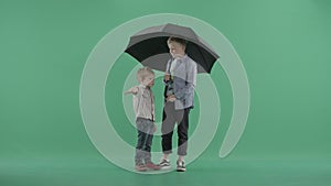 Two kids standing with an umbrella