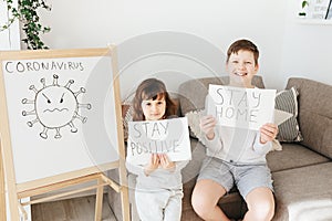 Two kids with Stay Home draw and Stay Positive draw