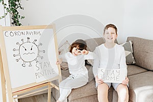 Two kids with Stay Home draw and Stay Positive draw