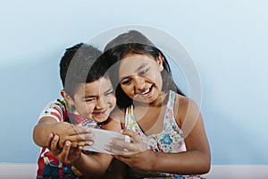 Two kids taking a selfie over blue background