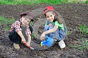 Two kids watering the sprout