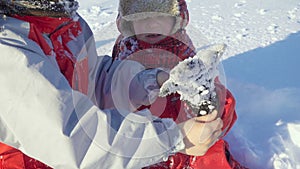 Two kids on winter park with sticky snow glowes