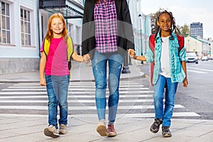 Two kids with woman walking on the street