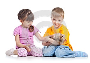 Two kidsplaying with kitten