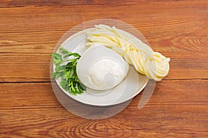 Two kinds of mozzarella cheese and parsley on a saucer