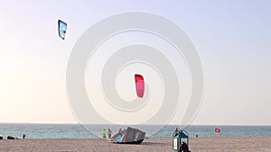 Two Kite-boarders jump on the beach