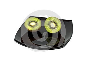 Two kiwis on a black plate, the top view