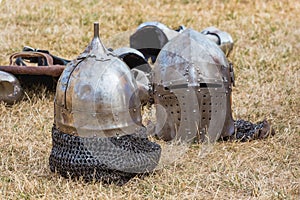 Two knightly helmets on the grass in the break between fights_