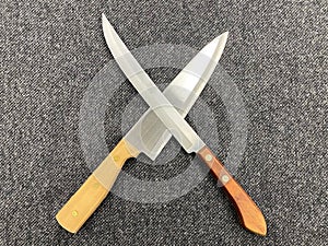 Two knives on a gray background, top view. ÃÂ¡ooking sign - two symmetric crossed knives. photo