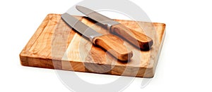 Two knives on a hardwood cutting board, essential tools in cuisine