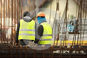 Two labours in yellow at the construction site