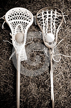 Two lacrosse heads and sticks with ball on grass photo