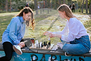 Two lady playing chess and having a chat