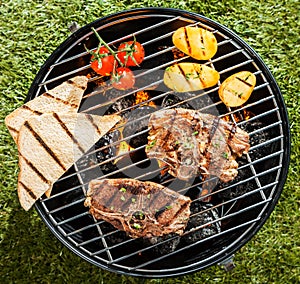 Two lamb chops cooking on a BBQ