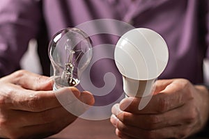 Two lamps in the hands of a man. Incandescent light bulb and LED light bulb in your hands