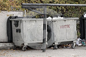 Two large metal dumpsters for paper and waste