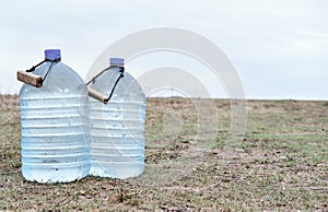 Two large plastic transparent carboys, capacity 5 gallons 19 liter, for water coolers with drinking water on a light background