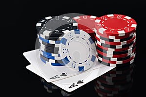 Two large playing cards with poker chips on a dark background