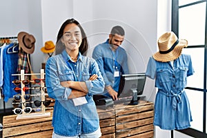 Two latin shopkeepers working at clothing store