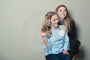 Two laughing female friends, isolated on grey backround. Copy space. Women fashion. Friendship, lifestyle, people and fashion conc