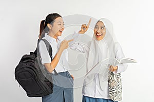 two laughing vocational high school girls carrying bags while chatting