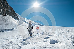 Two laughing young women Rope team descending Mont blanc du Tacul summit 4248m dressed mountaineering clothes with ice axes