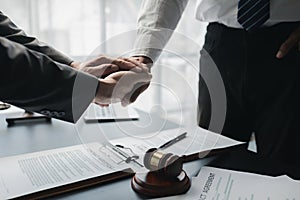 Two lawyers shake hands in a brainstorming meeting. Lawyers search for legal information together to plan how to represent clients