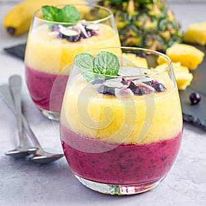 Two layer smoothie with black currant, quick oats, yogurt and pineapple, banana, square