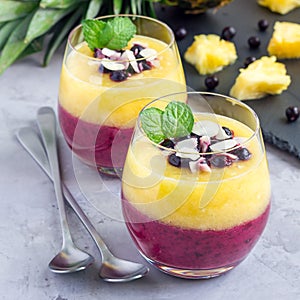 Two layer smoothie with black currant, quick oats, yogurt and pineapple, banana, square