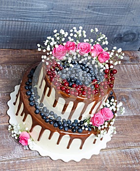 Two layered color drip wedding cake with bilberries, red currant