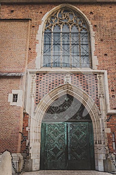 two-leaf metal door under a semicircular arch of stone with a beautiful window