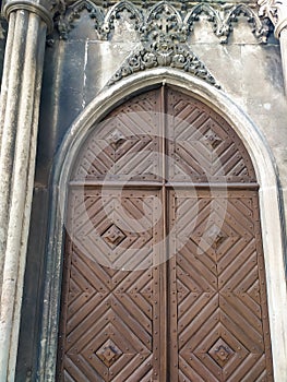 two-leaf wooden door under a semicircular arch of stone