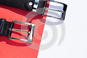 Two leather men`s belts on colored background