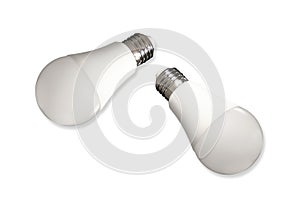 Two led bulb lights and energy-saving lamps on table on white background