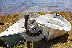 Two leisure boats locked with chains on land