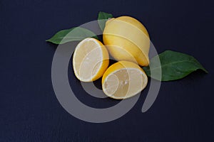 Two lemons on a black slate background