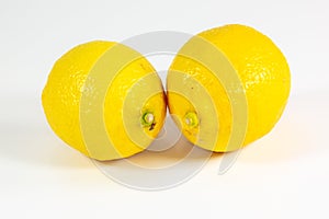 Two lemons on a white kitchen counter waiting to be sliced