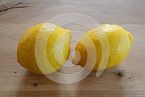 Two lemons on wooden table top