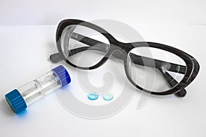 Two lenses, a container and glasses.