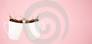 Two levitating coffee mugs with splashes and heart confetti. Coffee concept. Minimal art trend. Solid pink background