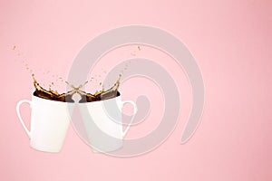 Two levitating coffee mugs with splashes and heart confetti. Coffee concept. Minimal art trend. Solid pink background