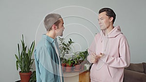 Two lgbt men are standing together in the living room and talking to each other