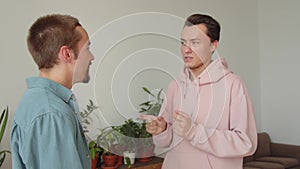 Two lgbt men are standing together in the living room and talking to each other, close up