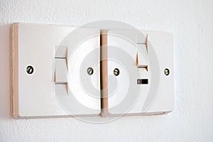 Two light switches on white wall.