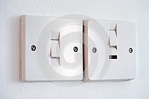 Two light switches on white wall.