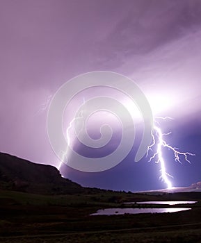 Two lightning bolts reflecting in water