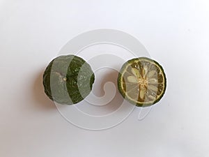 Two limes with one clipped on a white background