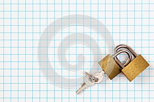 Two linked padlocks lying on square paper