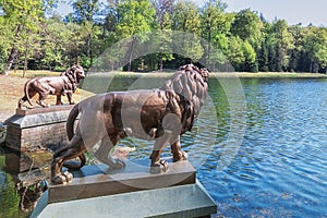 Two lion statues guard the pond in Het Loo Park