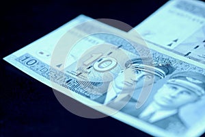 Two Lithuanian banknotes on a dark surface. Ten and twenty litas close-up. Money background blue color toned